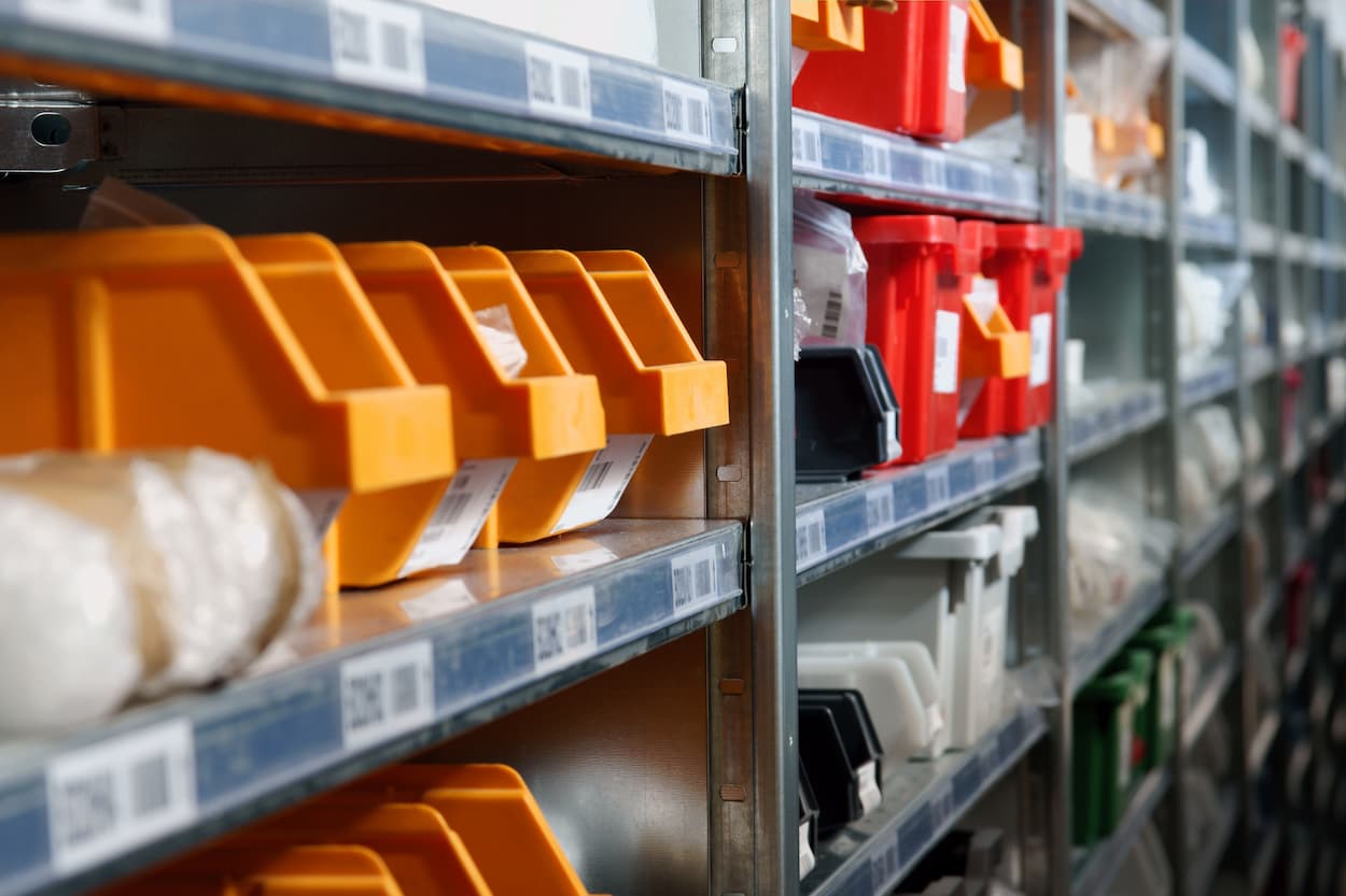 Parts lined up in containers on a shelf