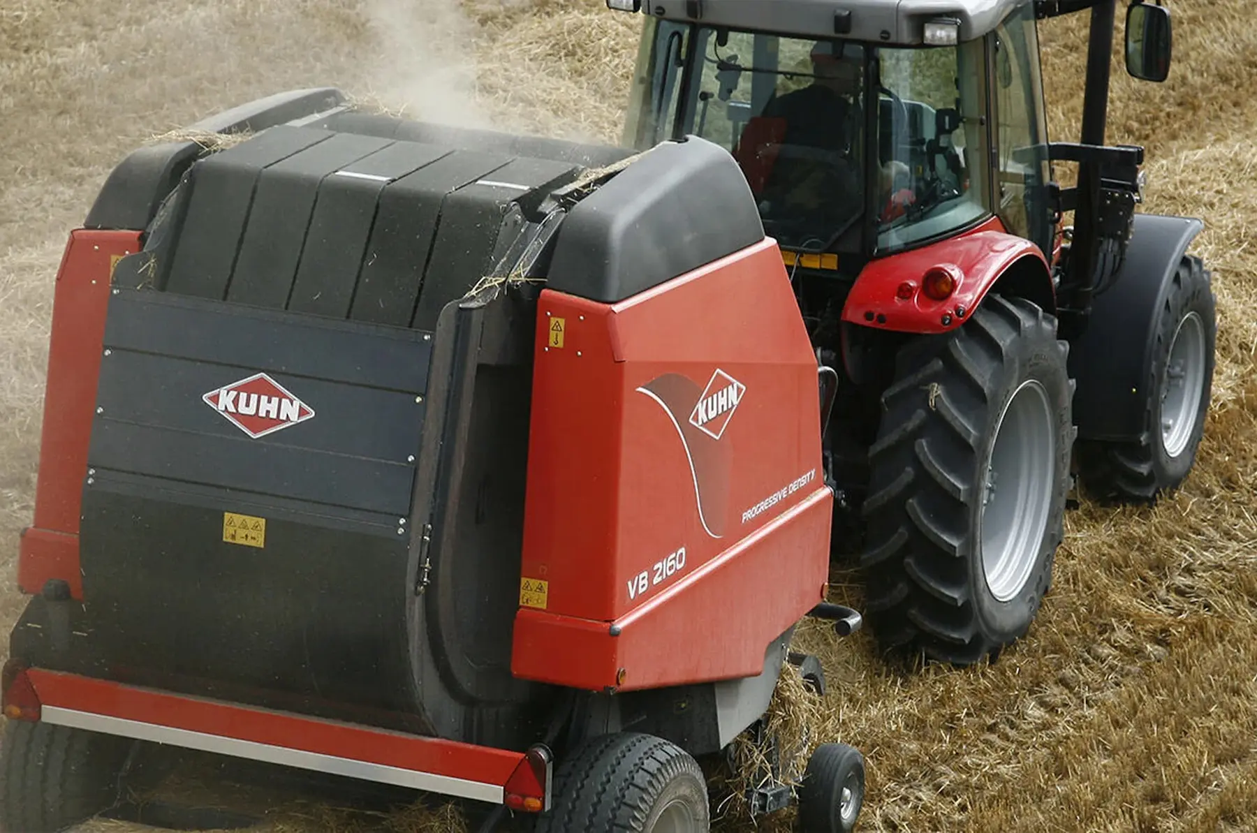 Kuhn Hay Baler being pulled by a red tractor