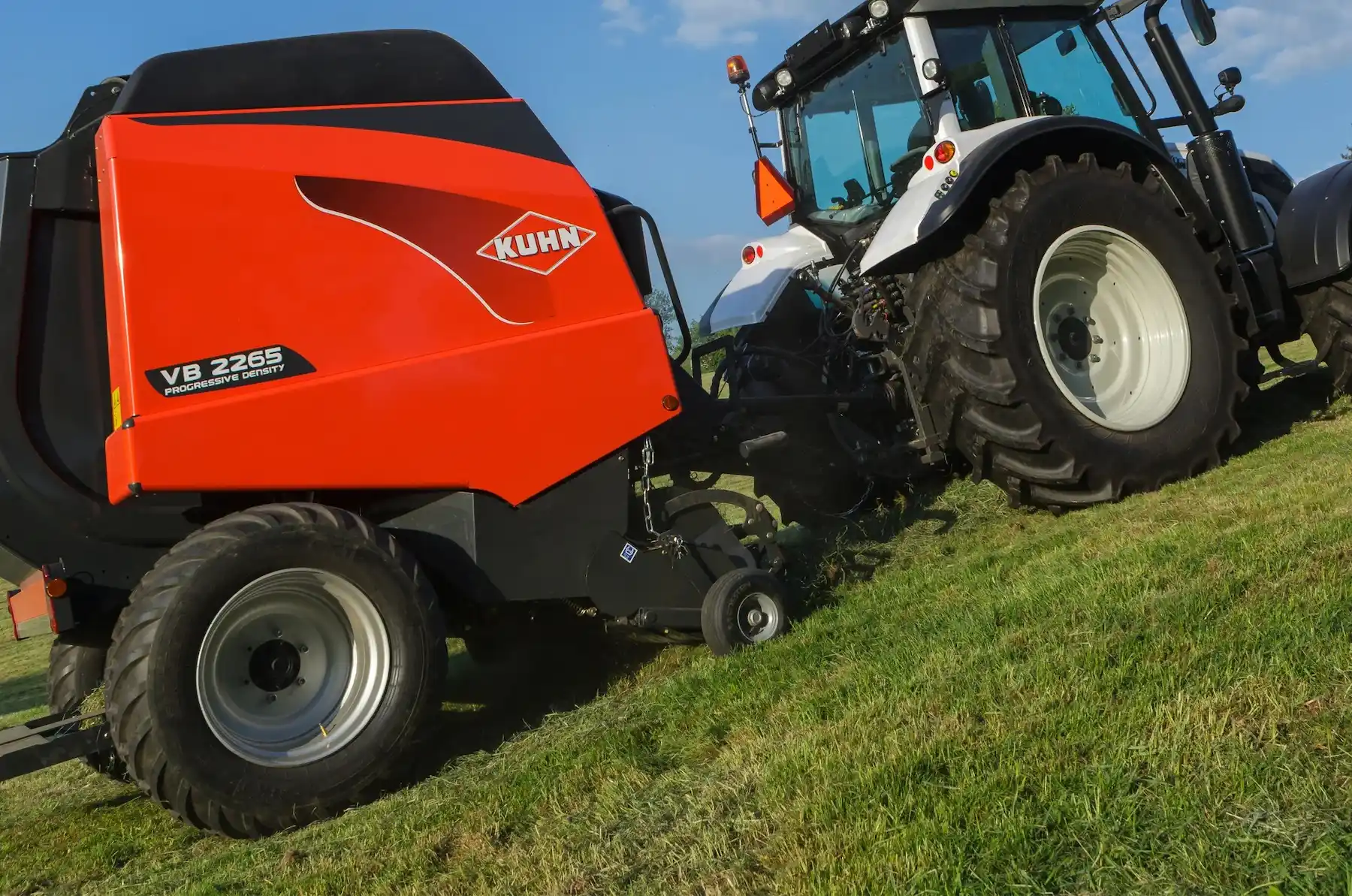 Kuhn Hay Baler being pulled by a white tractor